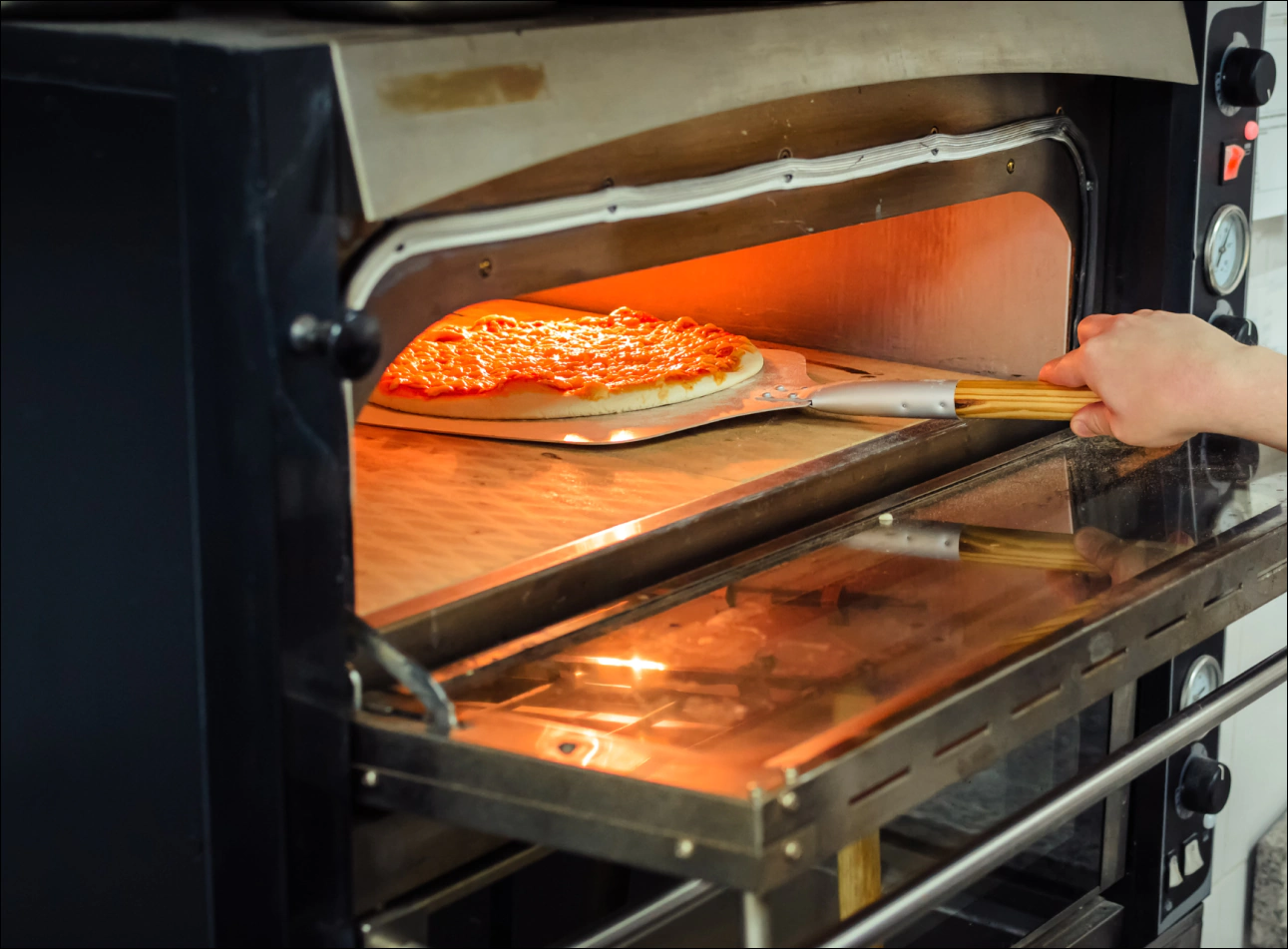 a pizza being cooked on an electric oven